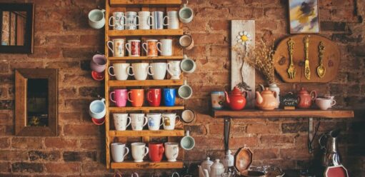 kolorowe kubki na drewnianej szafce i ceglanej ścianie