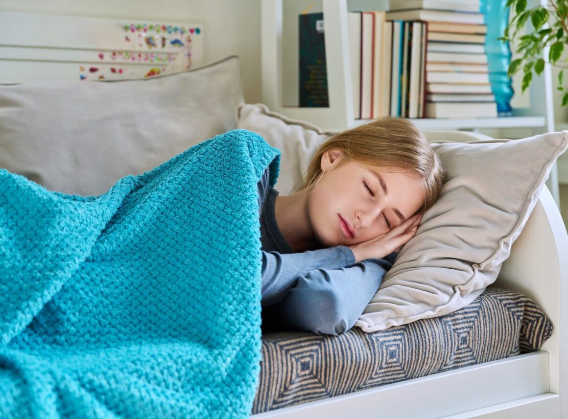 dziewczyna śpiąca pod niebieskim kocem