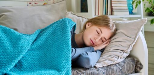 dziewczyna śpiąca pod niebieskim kocem