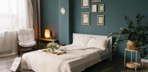 sypialnia z ciemnozielonymi ścianami i łóżkiem z białą narzutą