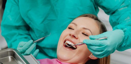 uśmiechnięta kobieta na fotelu dentystycznym podczas zabiegu