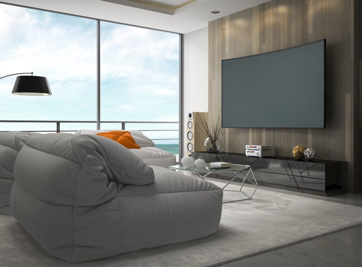 nowoczesny salon z kinem domowym i szarą sofą