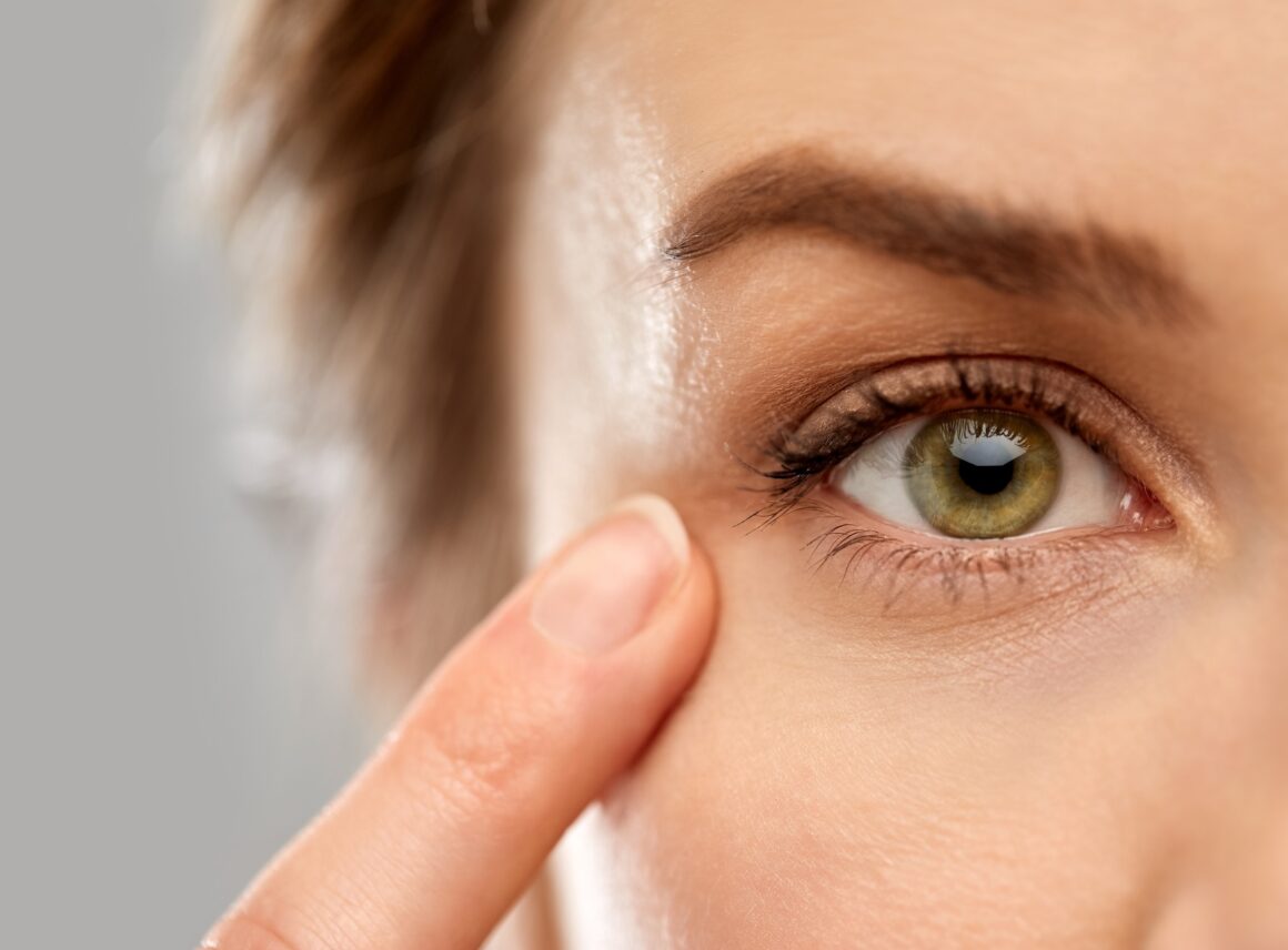 kobieta z palcem przy oku