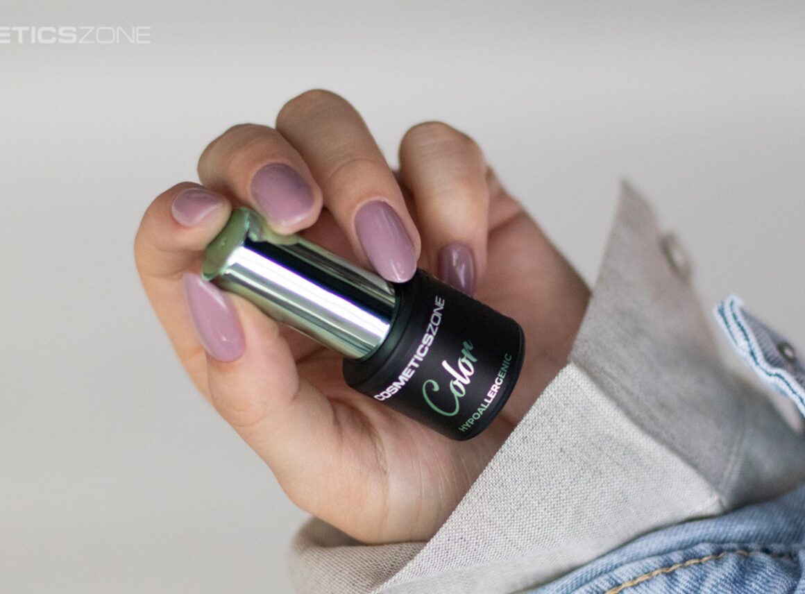 dłoń kobiety trzymająca lakier do paznokci