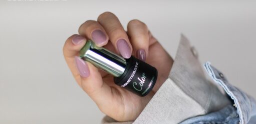 dłoń kobiety trzymająca lakier do paznokci