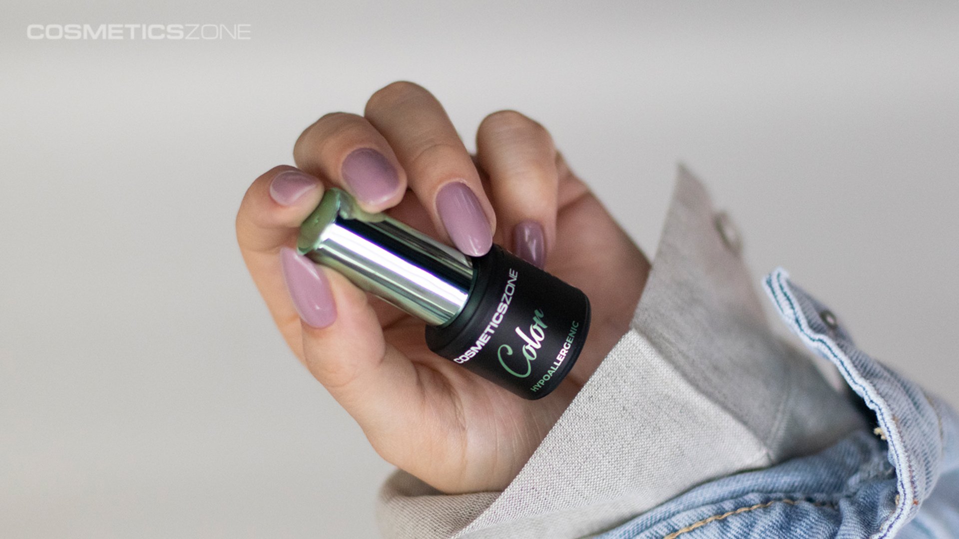 dłoń kobiety trzymająca lakier do paznokci