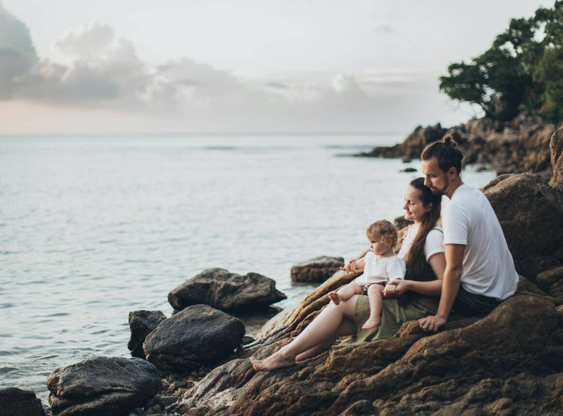 rodzice i dziecko na skałach nad wodą